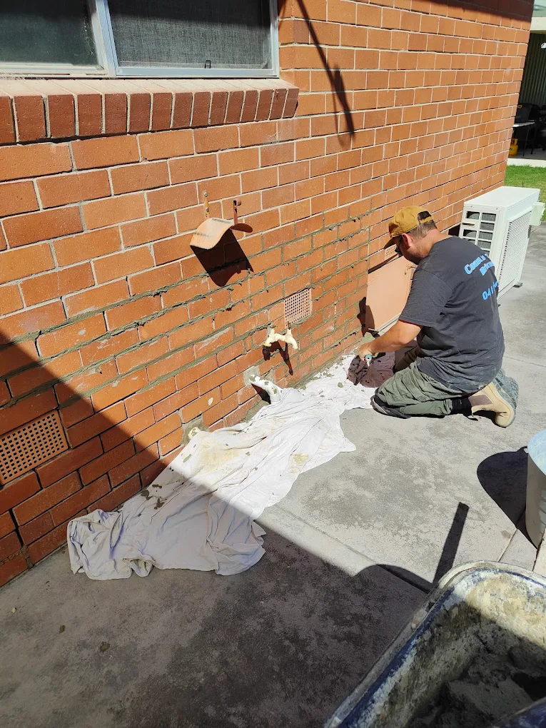 John at work repointing a brick wall